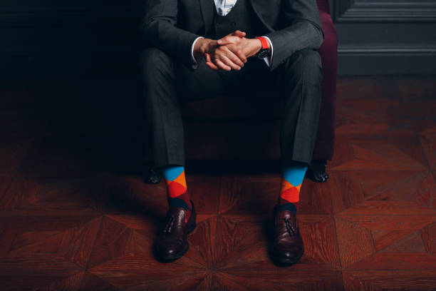 Portrait of a businessman in strict gray suit and colorful multi colored socks. Business and success concept.