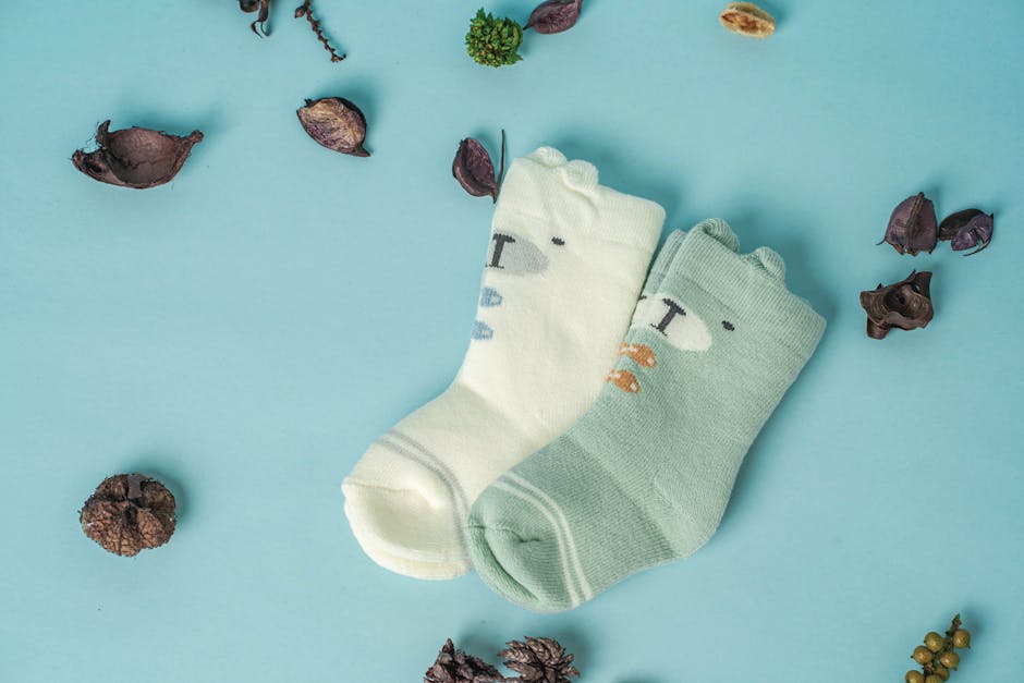 pexels-photo-14195487-14195487 Adorable baby socks on a pastel blue background with decorative elements, perfect for baby fashion themes.