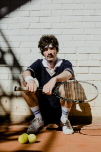 pexels-photo-5730295-5730295 Stylish man in vintage tennis attire with racket and balls outdoors.