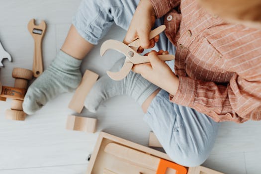 pexels-photo-7269580-7269580 Overhead shot of a child playing with wooden toy tools indoors, fostering creativity.
